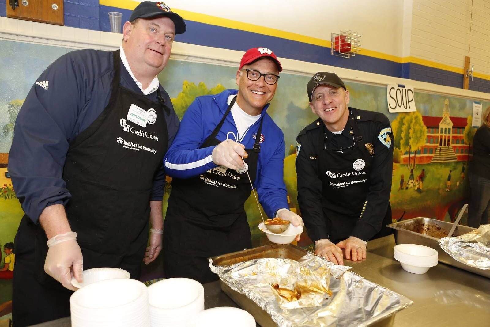 Madison Fire Chief Steven Davis, and former Police Chief Mike Koval serve soup with John at Habitat for Humanity's "Souper Bowl".