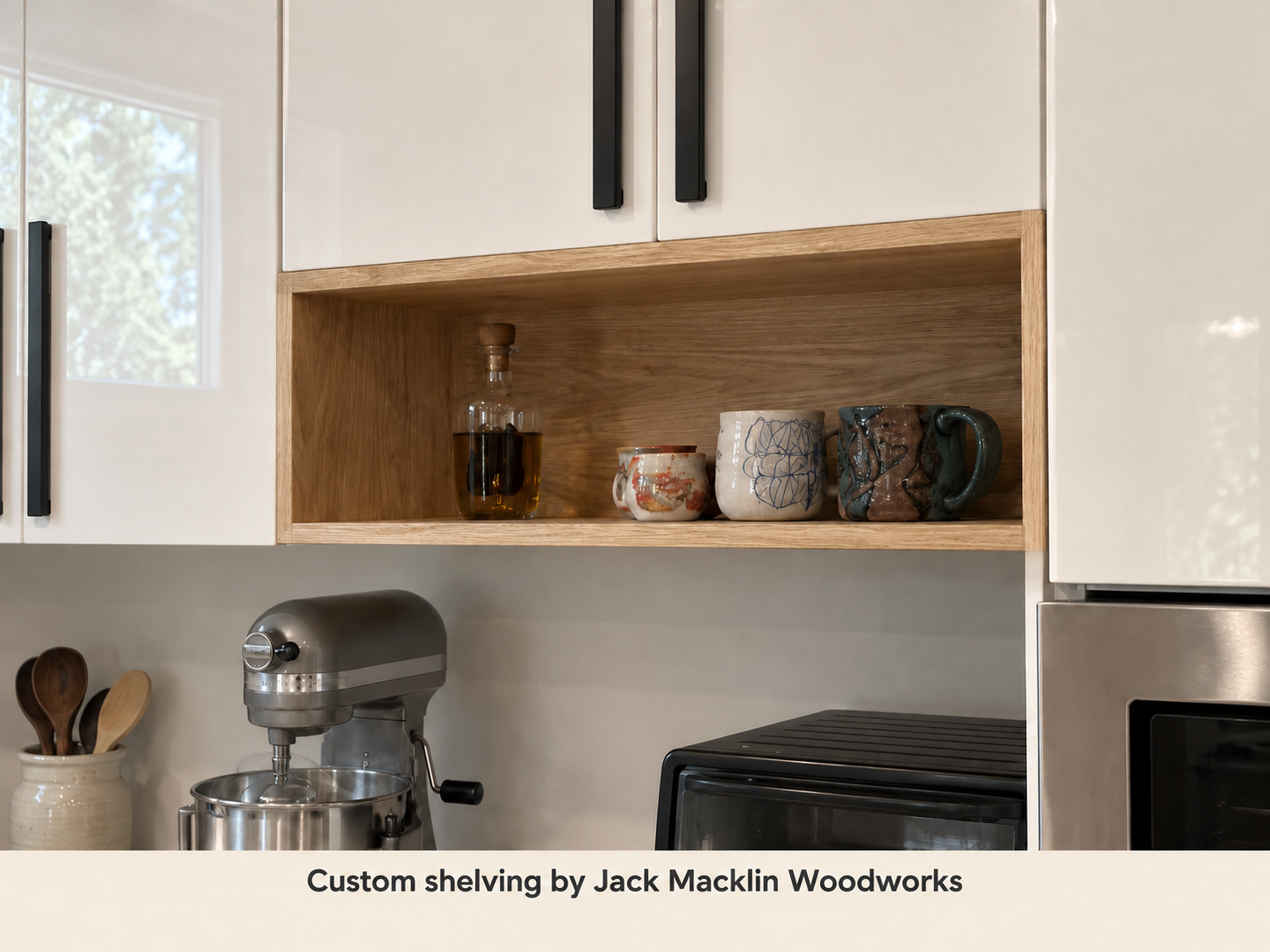 Kitchen shelves with decorative mugs, a bottle of oil or vinegar, and kitchen appliances including a stand mixer and oven.