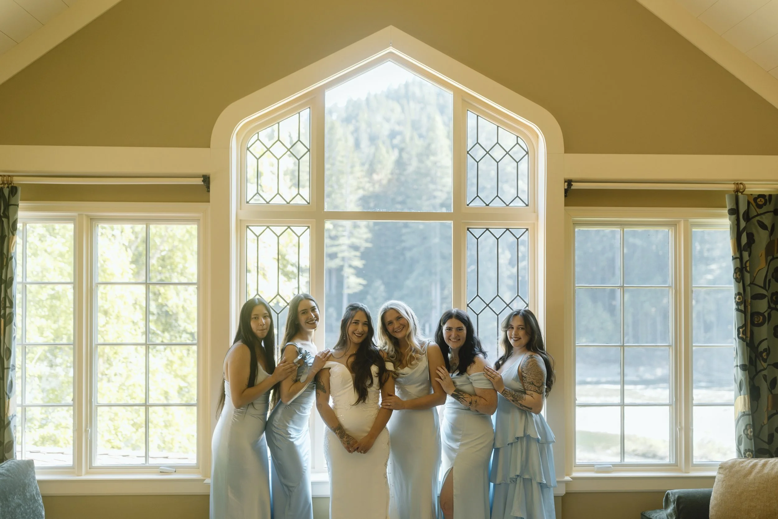 Bridesmaids in primary suite against large window