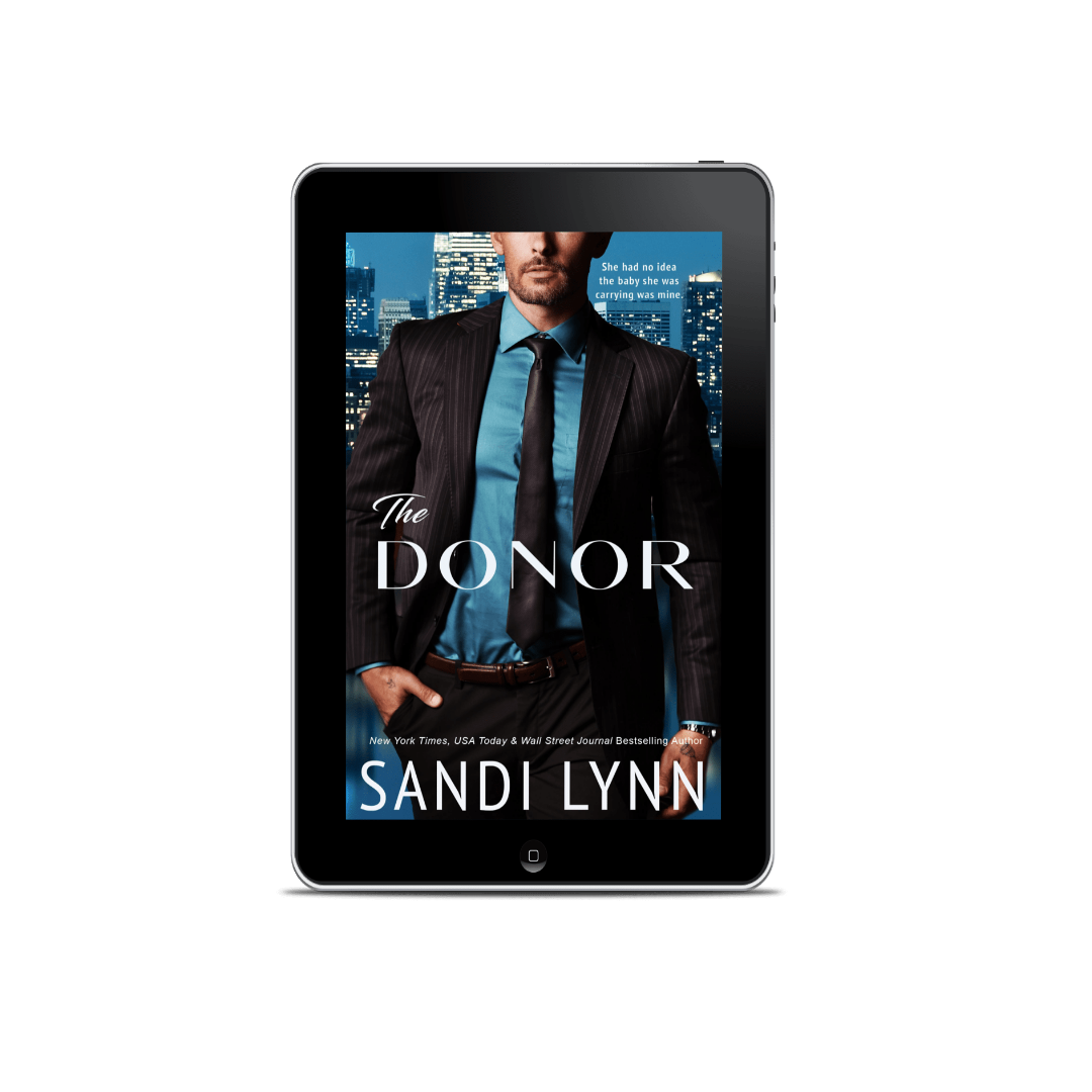 E-book cover of 'The Donor' by Sandi Lynn, featuring a man in a suit with a city skyline background, displayed on a tablet with a laptop in the background.