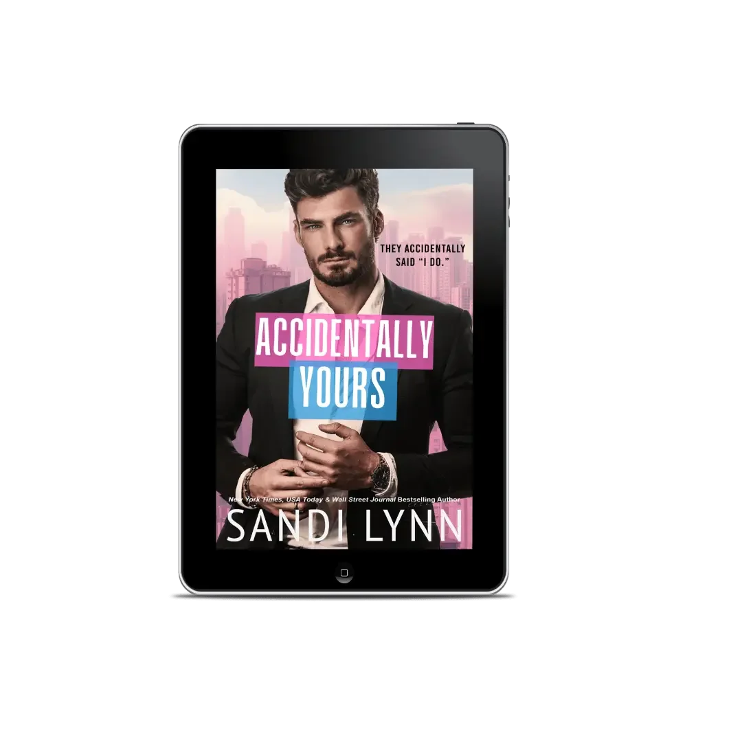 E-book cover titled 'Accidentally Yours' by Sandi Lynn displayed on a tablet device, featuring a man in a suit with a city skyline background.