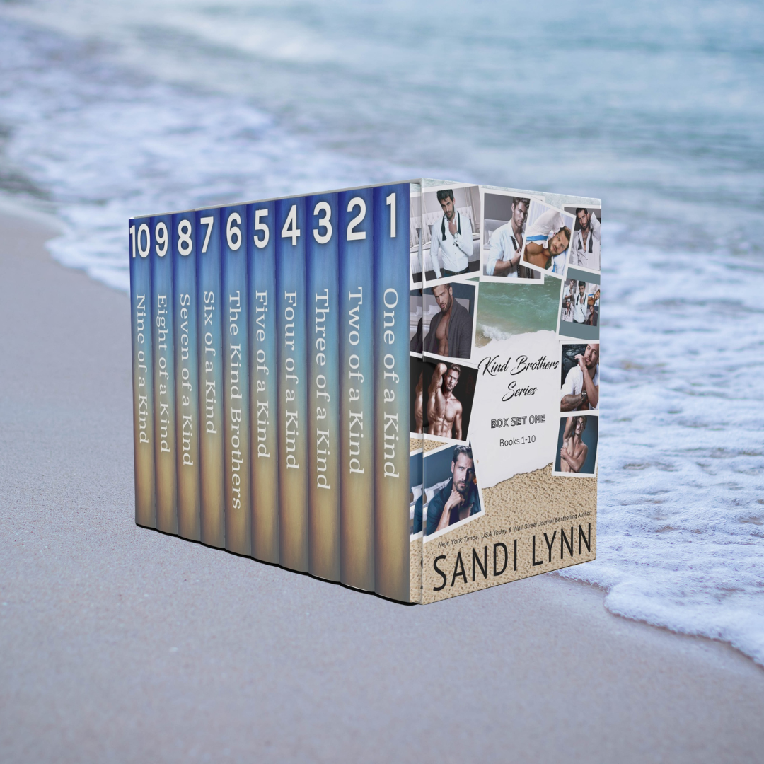 A boxed set of books titled 'Kind Brothers Series' by Sandi Lynn, featuring ten books with numbered titles from 1 to 10, placed on the sand at the edge of the ocean with waves in the background.
