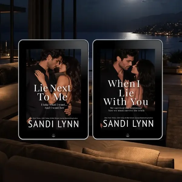 Two digital tablets displaying book covers by Sandi Lynn, with romantic couple images and titles, in a cozy living room with a waterfront view at night.