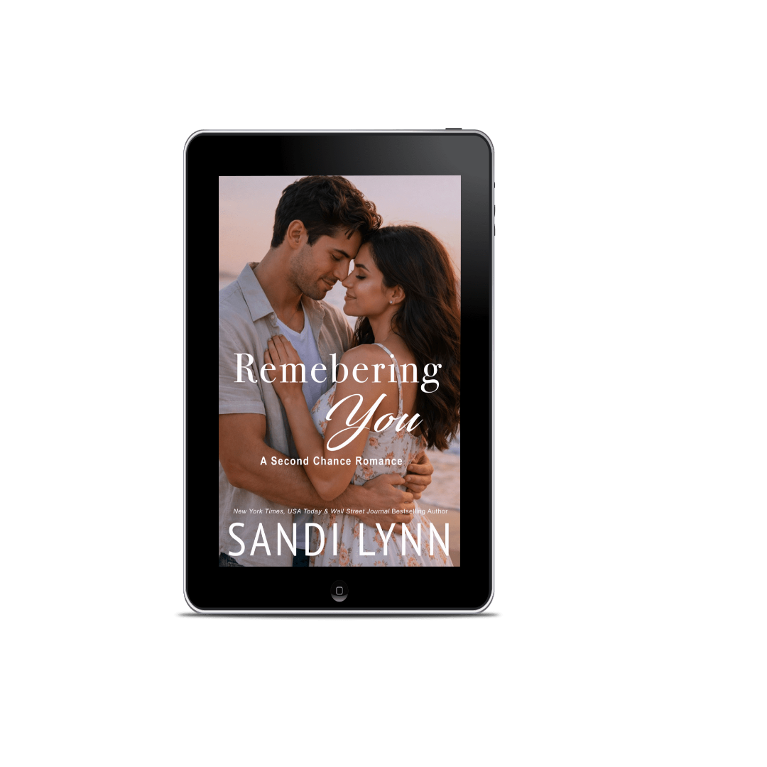 E-book cover titled 'Remembering You' by Sandi Lynn featuring a romantic photo of a man and woman embracing on a beach at sunset.