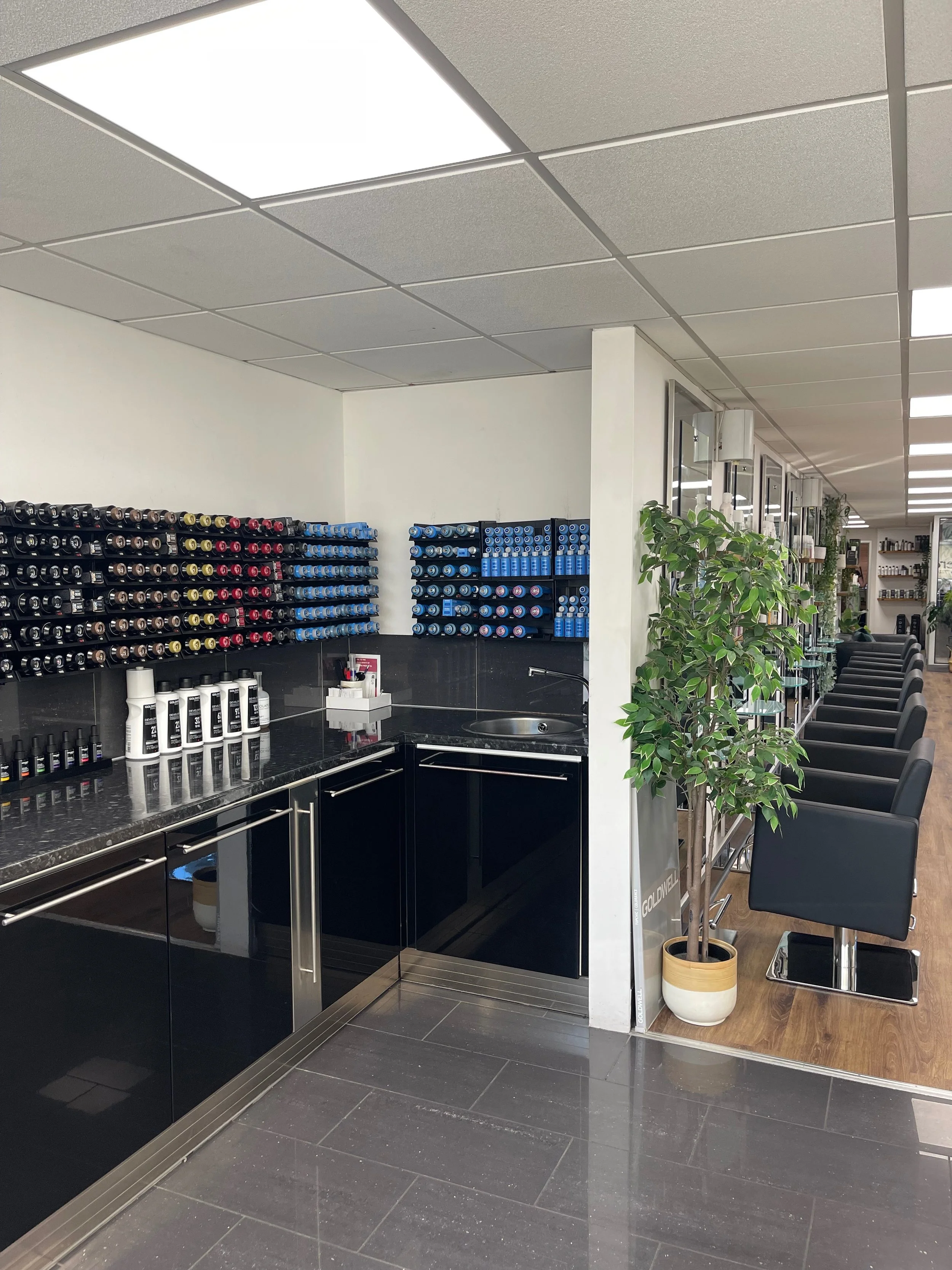 Colour mixing station in hair salon, near basin area.