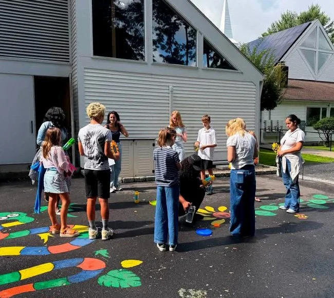 Kids playing a game painted on the pavement outside the church