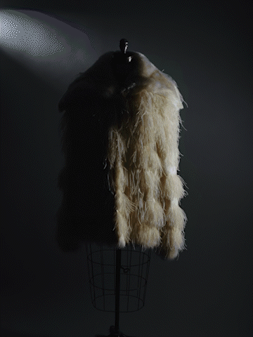 Fur or textile draped over a mannequin or stand with a light shining from behind.