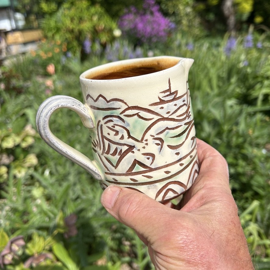 pot2852 - Milk jug with sunbathers and seascape. Wave border. Caramel glaze inside.