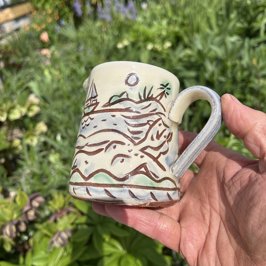 pot2853 - Milk jug with women sunbathers and seascape. Wave border. Caramel glaze inside.