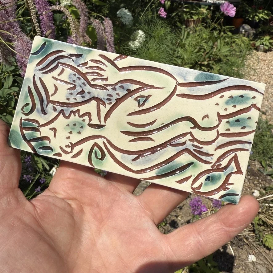 pot3023 Medium rectangular tile with kissing guys in the river.