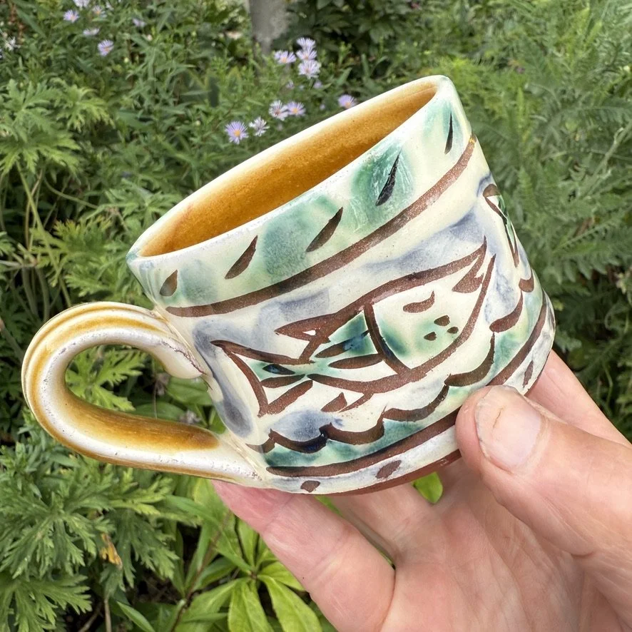 pot3048 Medium coffee mug with fishys border. Signature on base. Caramel glaze on handle and inside.