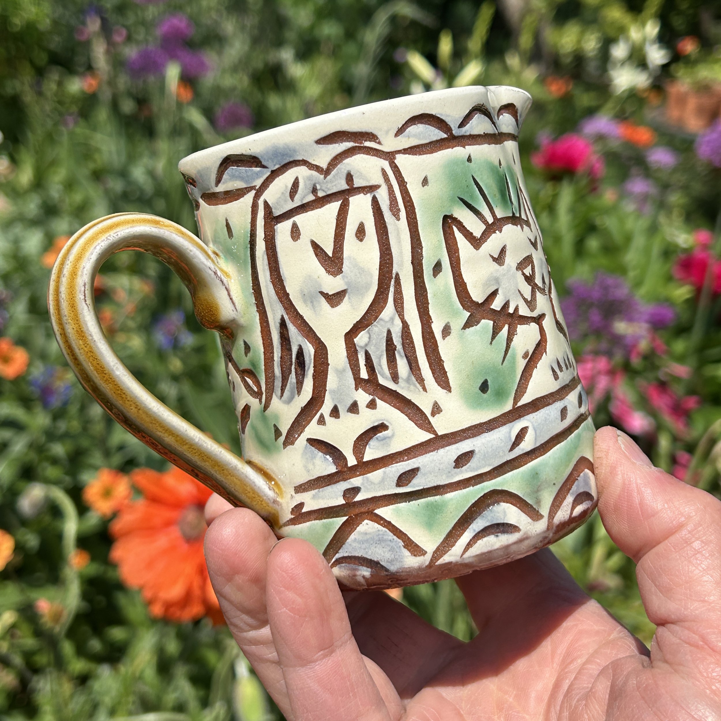 pot2908 - Milk jug with folks, cat and 2 dogs. Caramel coloured handle and inside.