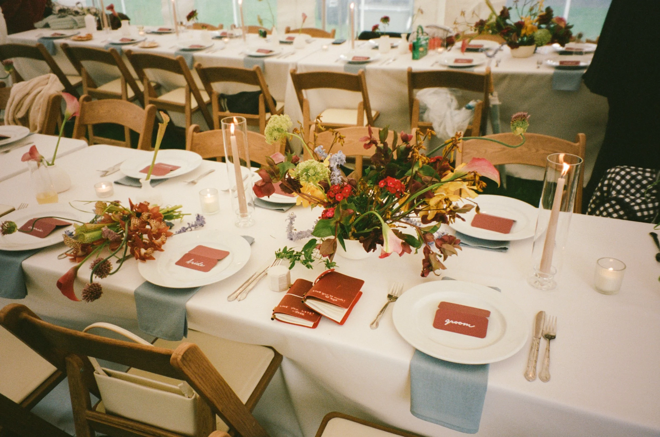 Intimate tablescape in brown, burgundy, and dusty blue, with hints of yellow for a tented wedding in the Hudson Valley. Film photography by Mikala Gallo Photography.