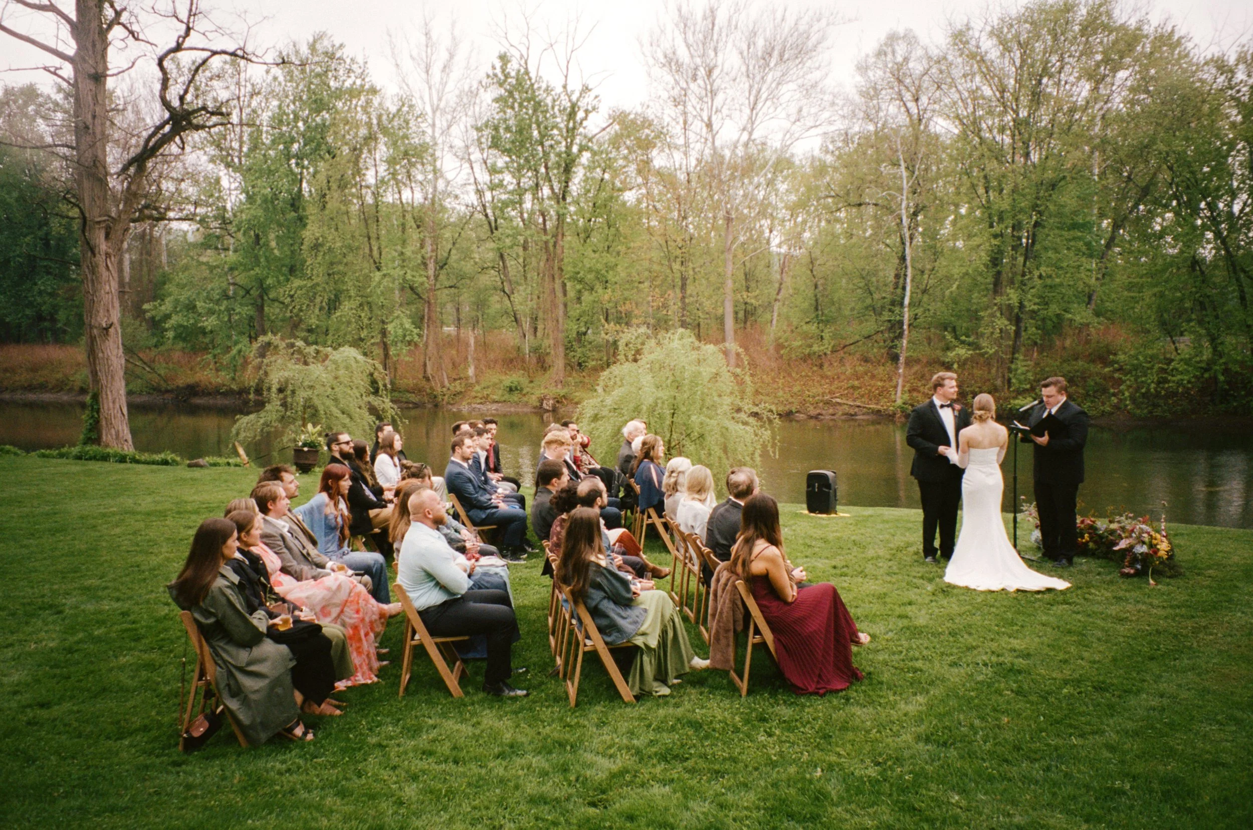 Sydney and Josh get married in front of iconic Leeds, NY bridge, with a unique fine art floral ceremony nest. Film photography by Mikala Gallo Photography.