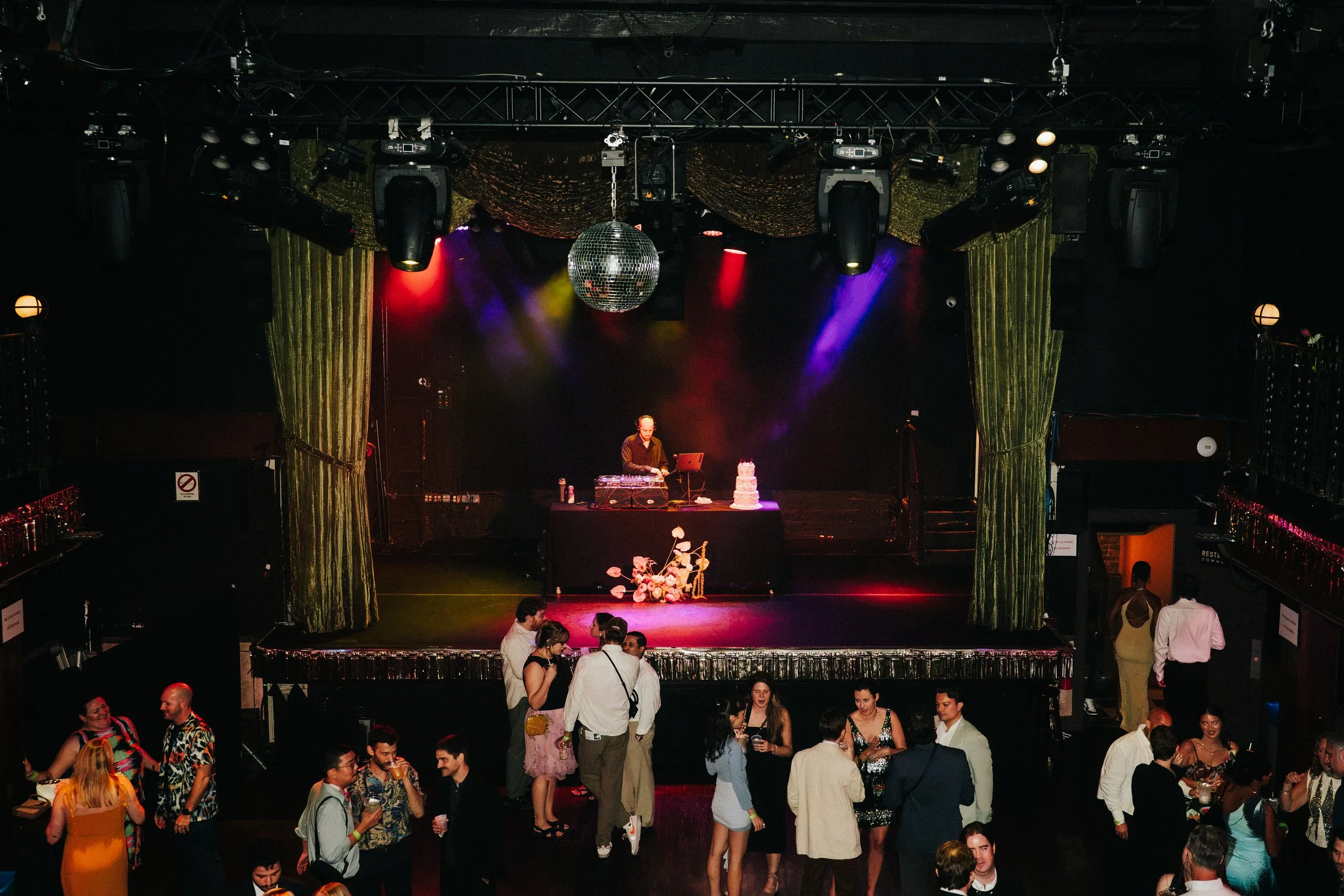 Rager wedding with technicolor wedding flowers adorned with citrus on the Lower East Side at the Bowery Ballroom. Photo by Inez Valencia.