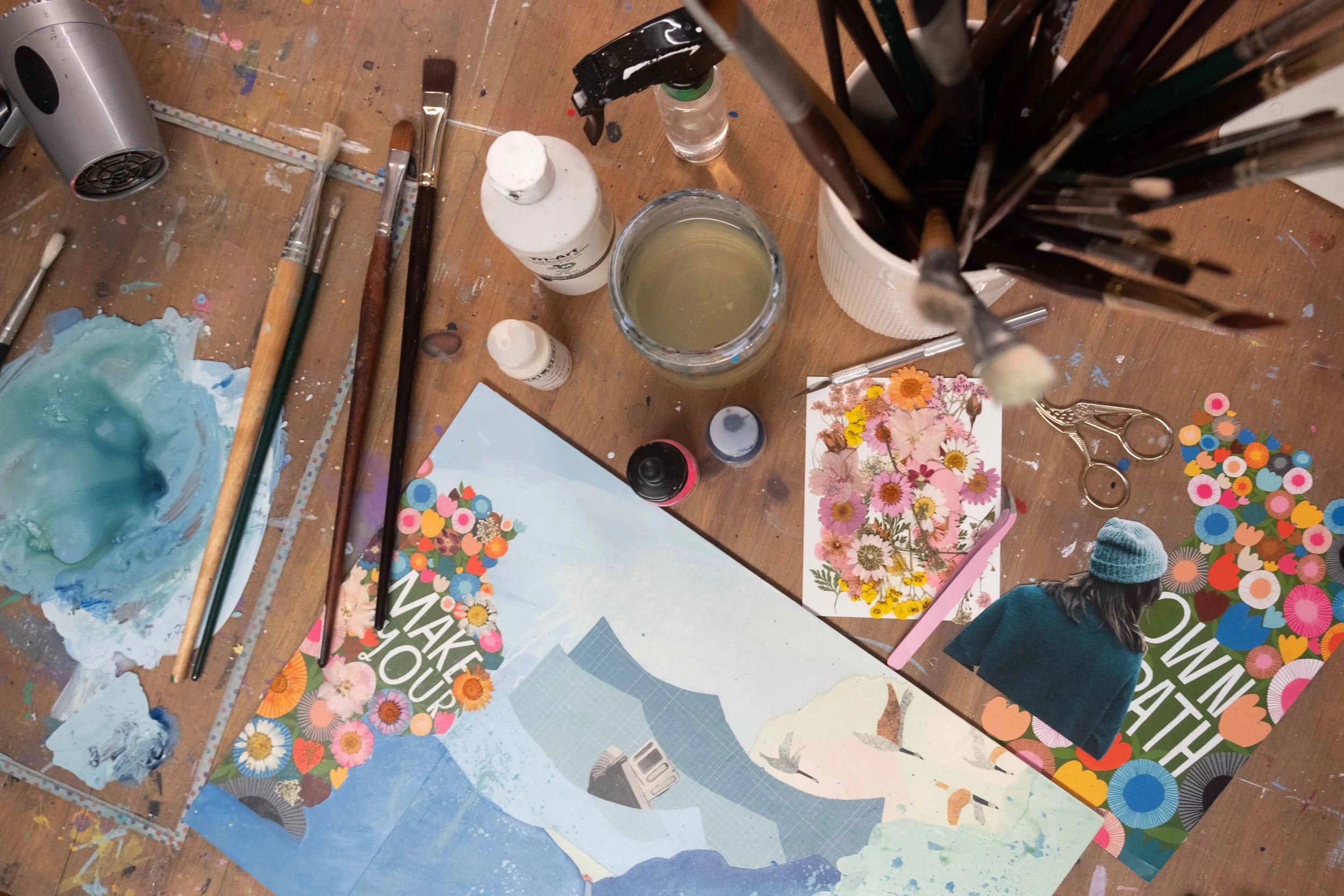 Atelier de Josée Landry, artiste multidisciplinaire au Bas-Saint-Laurent, avec outils de peinture, techniques mixtes et œuvres florales en cours de création.