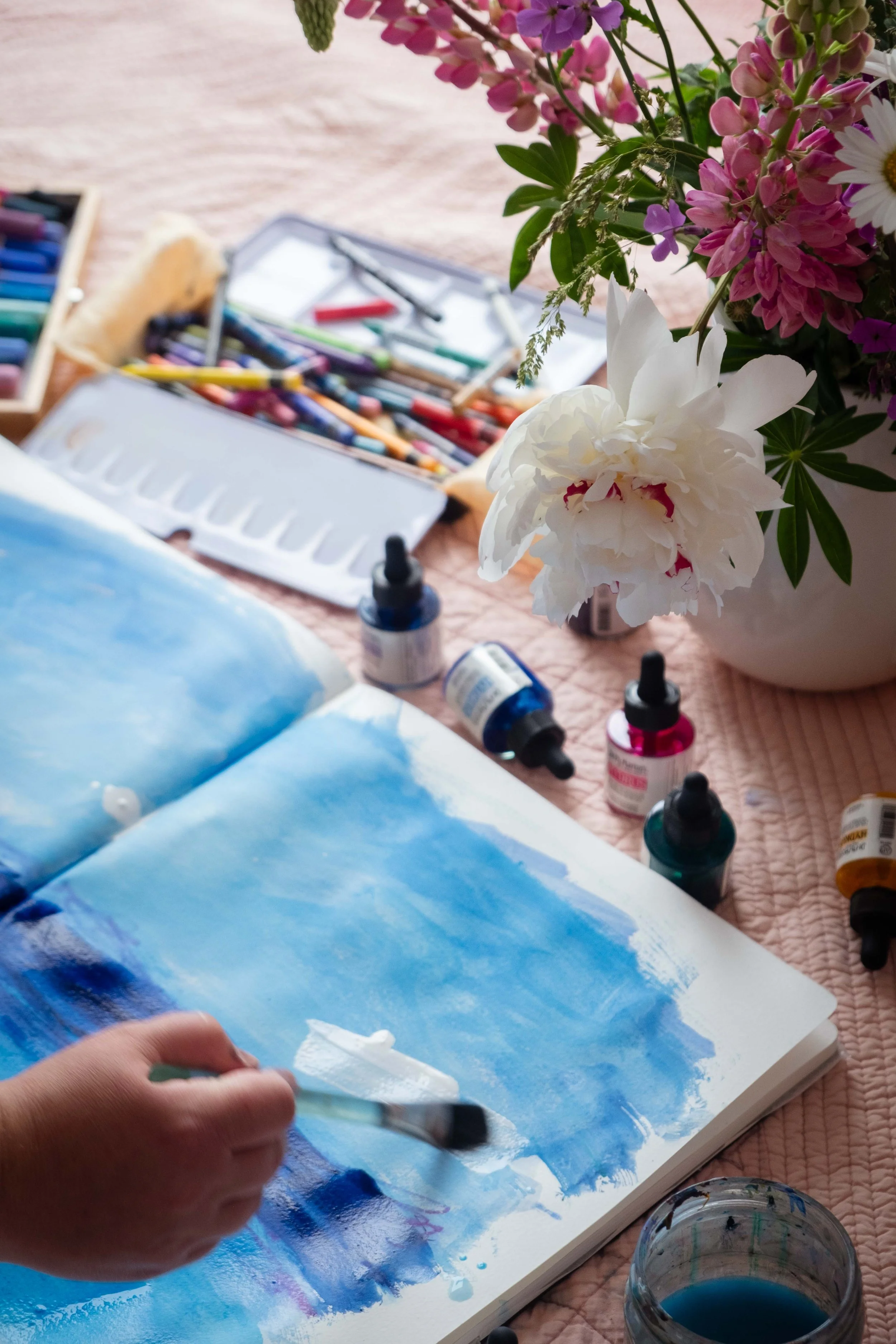 Josée Landry, artiste multidisciplinaire, peignant une toile à l'acrylique dans son atelier du Bas-Saint-Laurent.