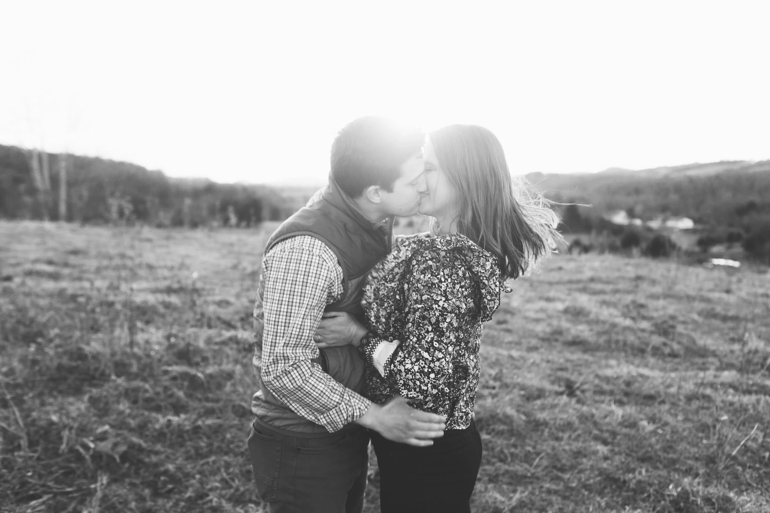 Couple Kissing at Sunset During Family Farm Winter Engagement Photo Session