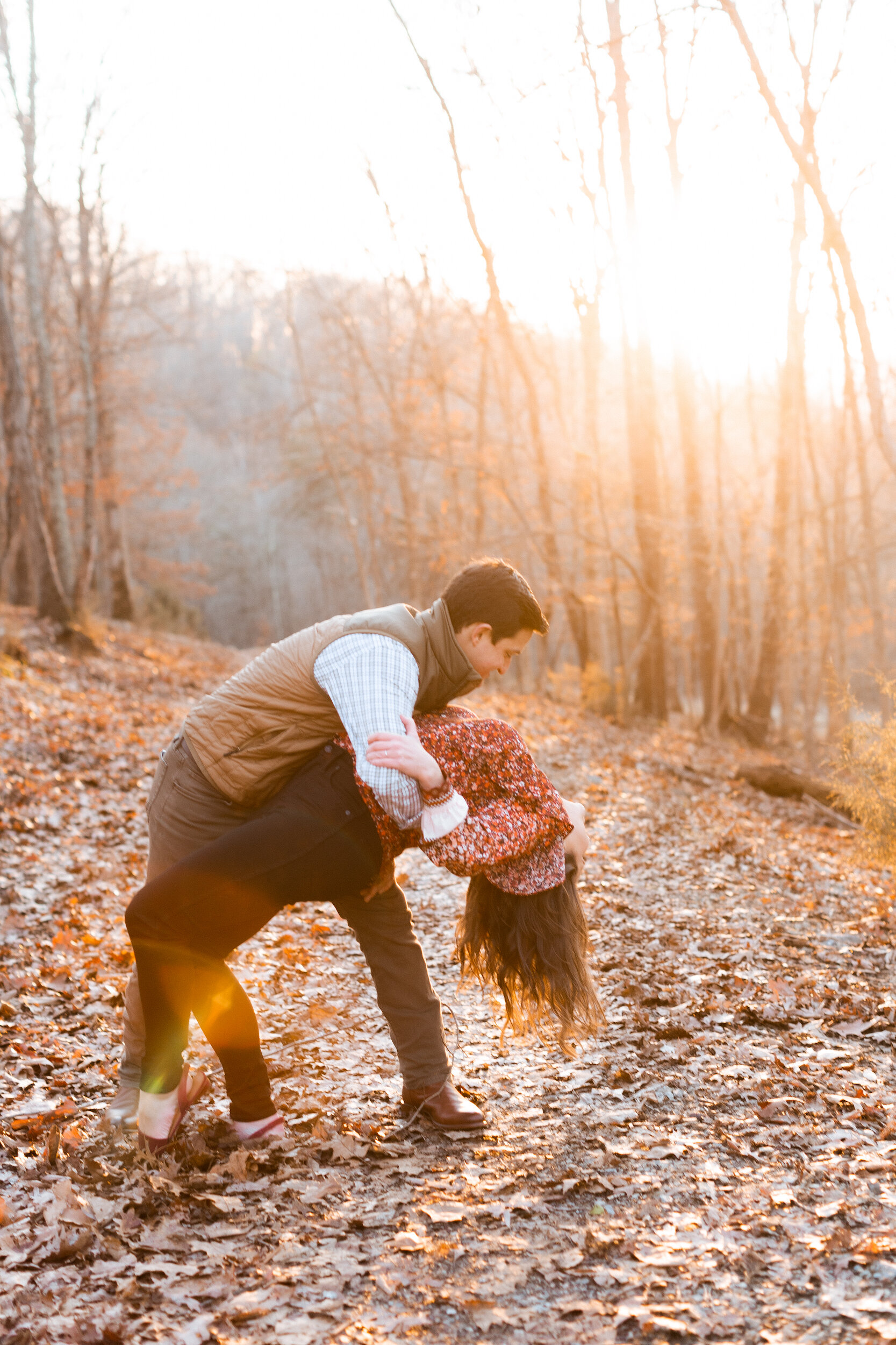 Couple Dancing at Sunset in the Woods During Family Farm Winter Engagement Photo Session