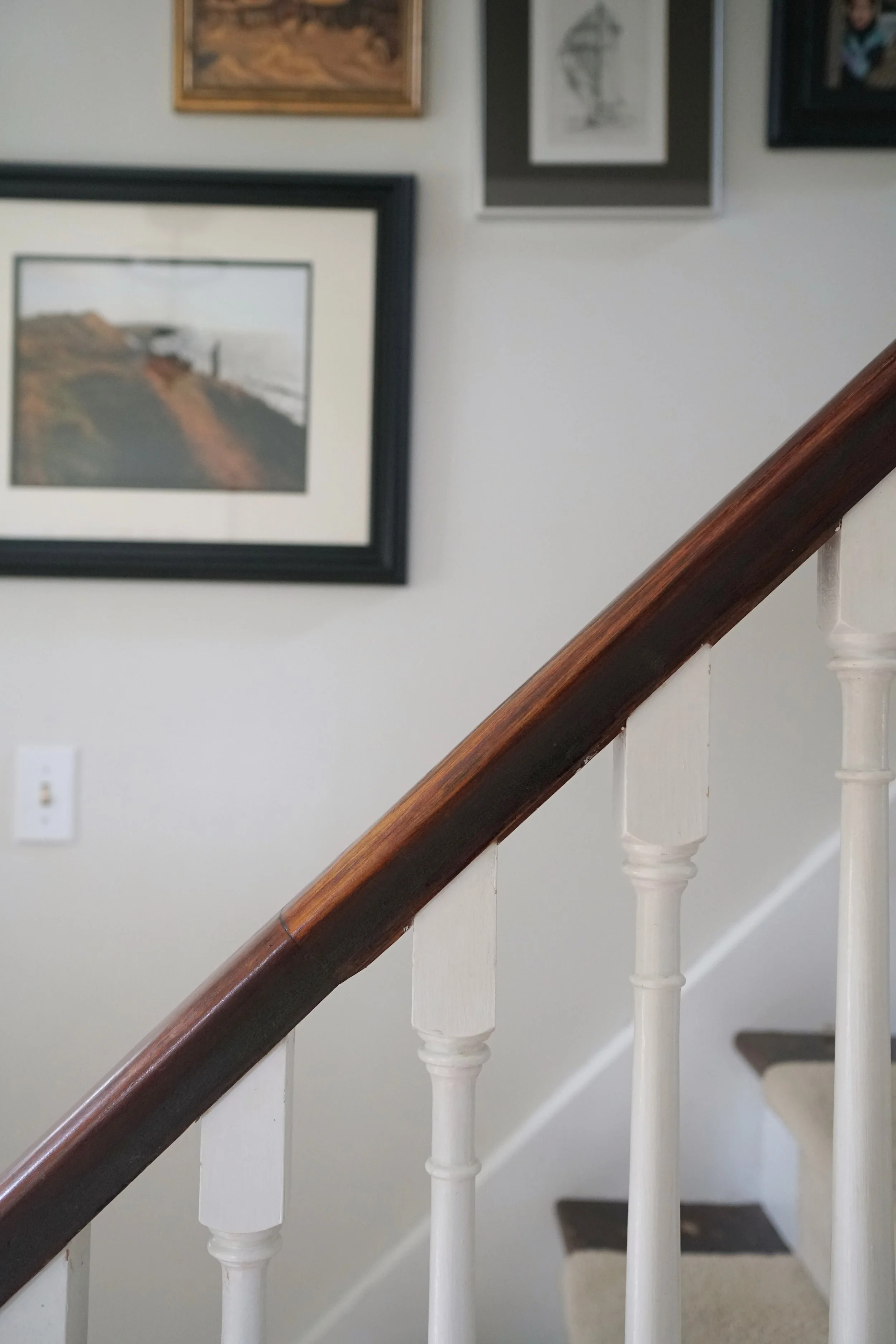 Gallery wall on wood and white staircase - Cheryl Lee Interiors