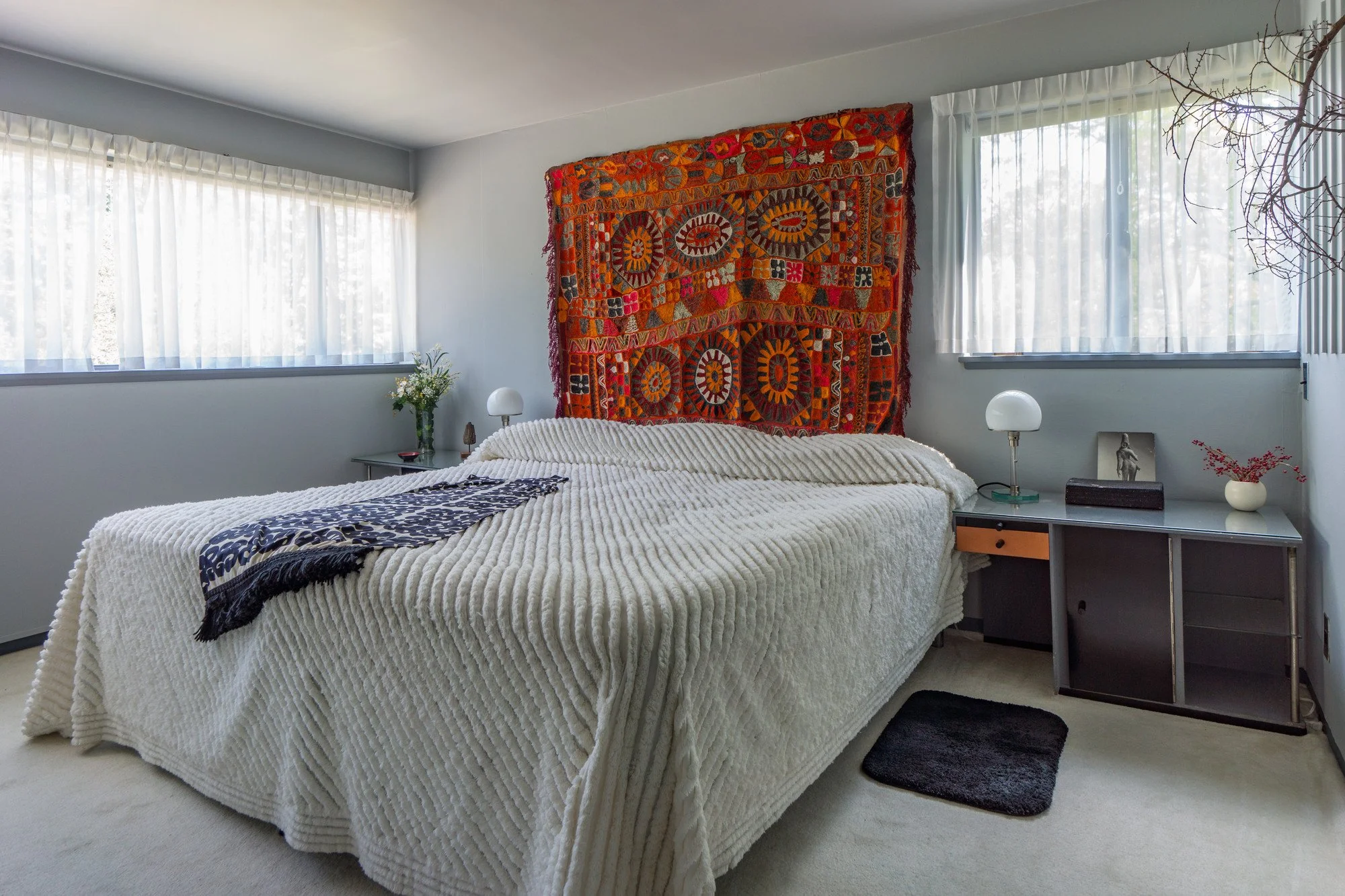 Bright orange rug on the wall of a modernist house