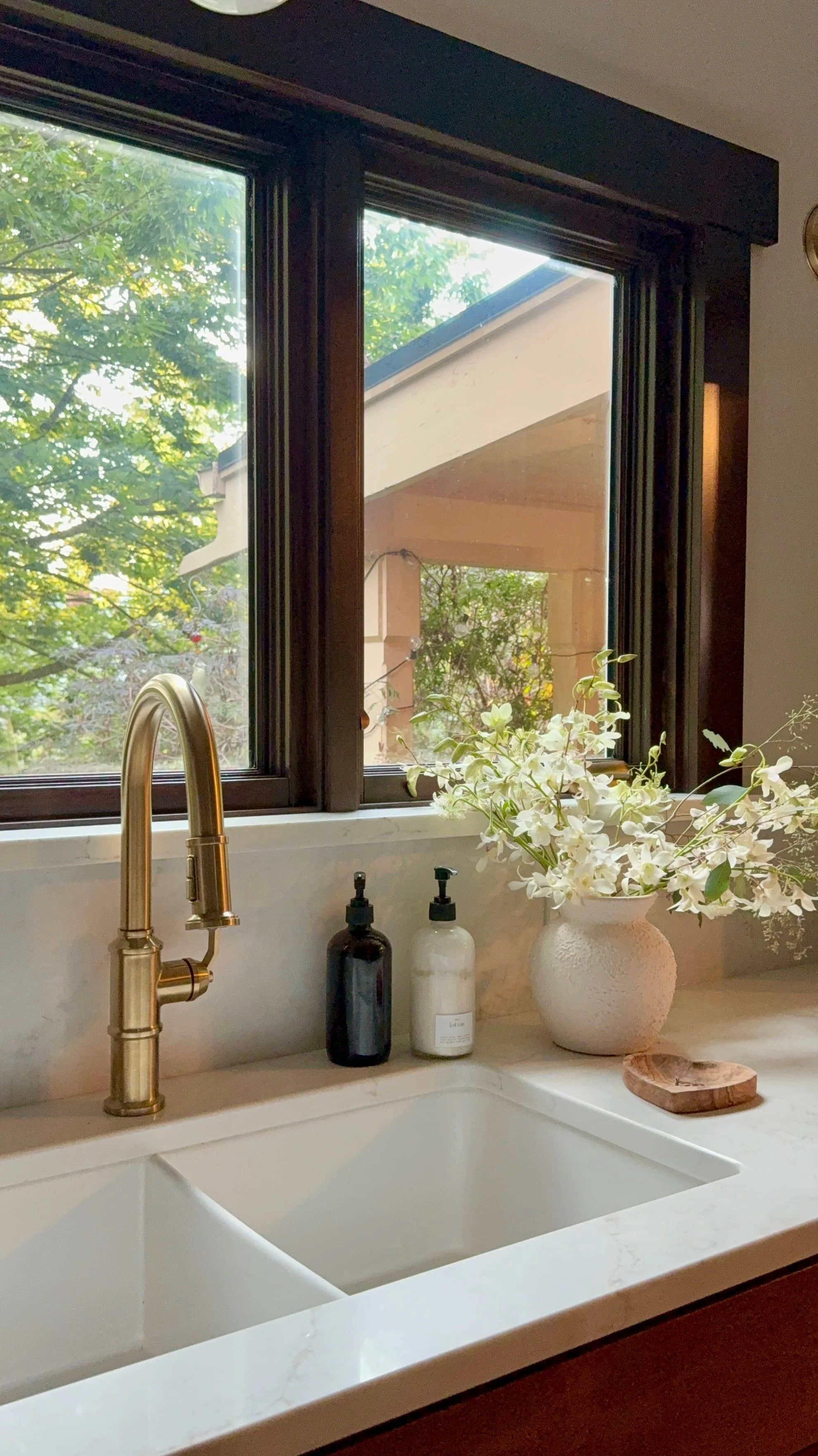 Custom kitchen design with brass faucet, integrated sink, and stone countertops in a Portland home
