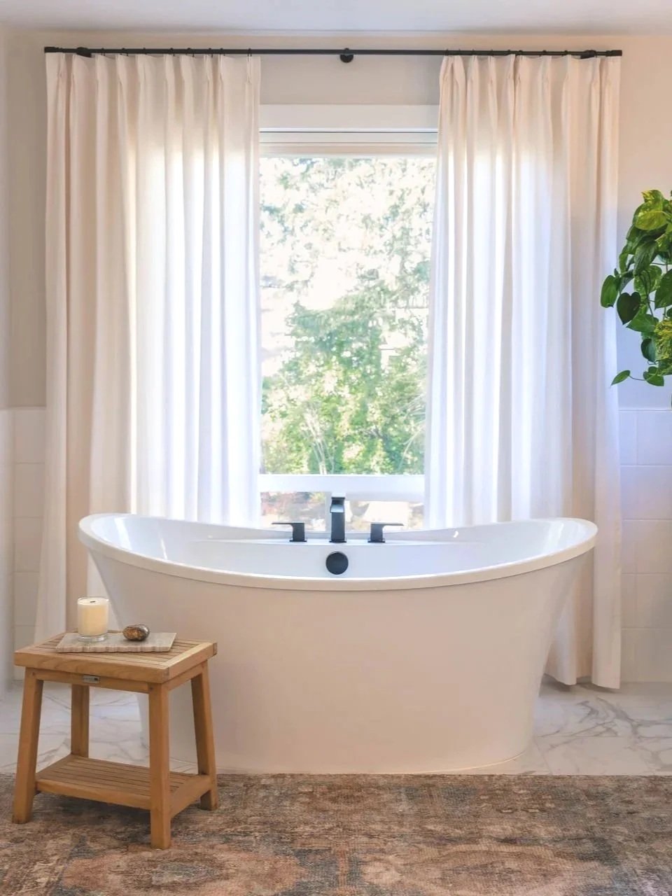 Bathroom with a freestanding soaking tub, soft natural light, and simple, intentional finishes.