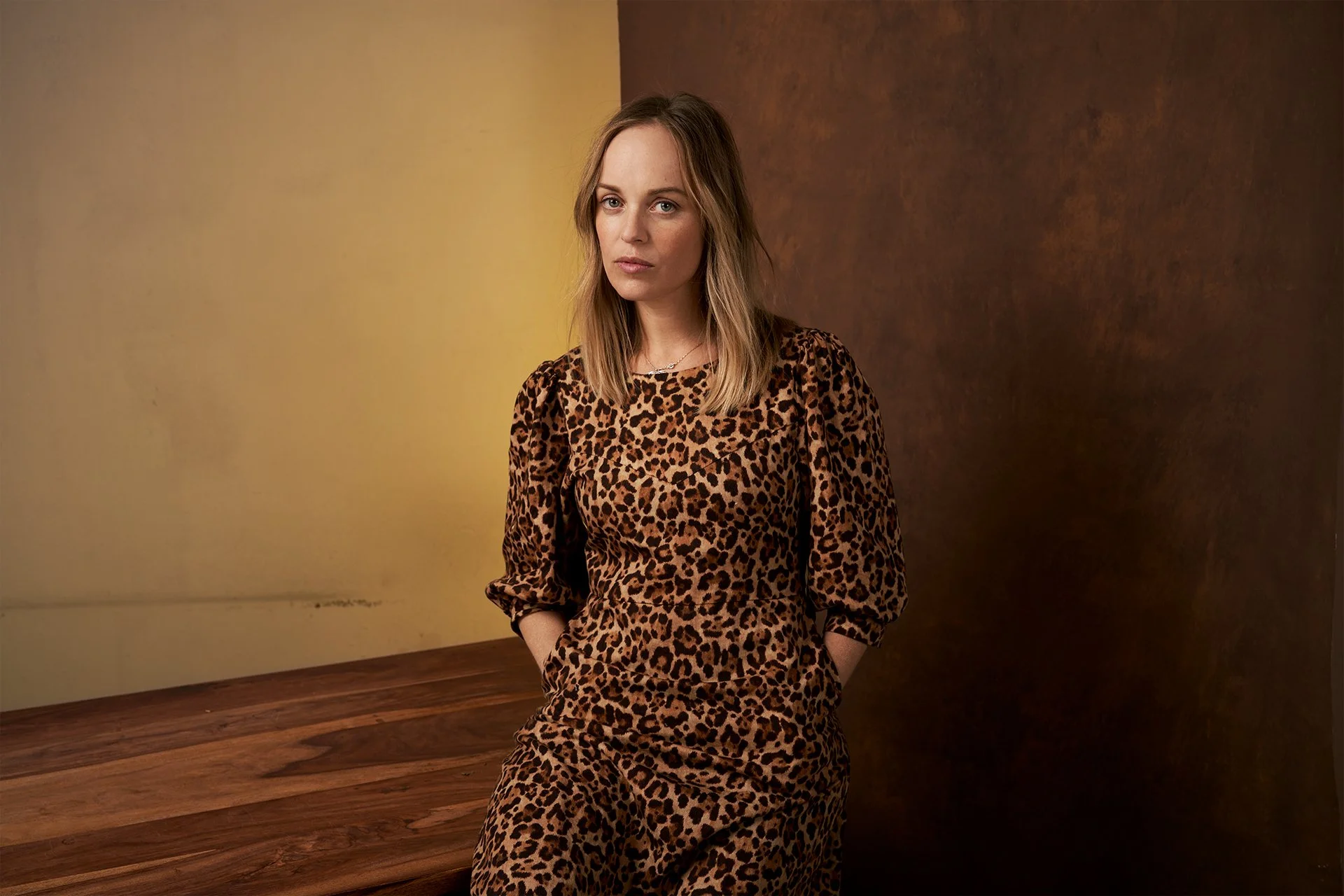 Schauspielerportrait von Frederike Kempter vor warmem Hintergrund, stilvolle Portraitfotografie in Berlin mit natürlichem Ausdruck.