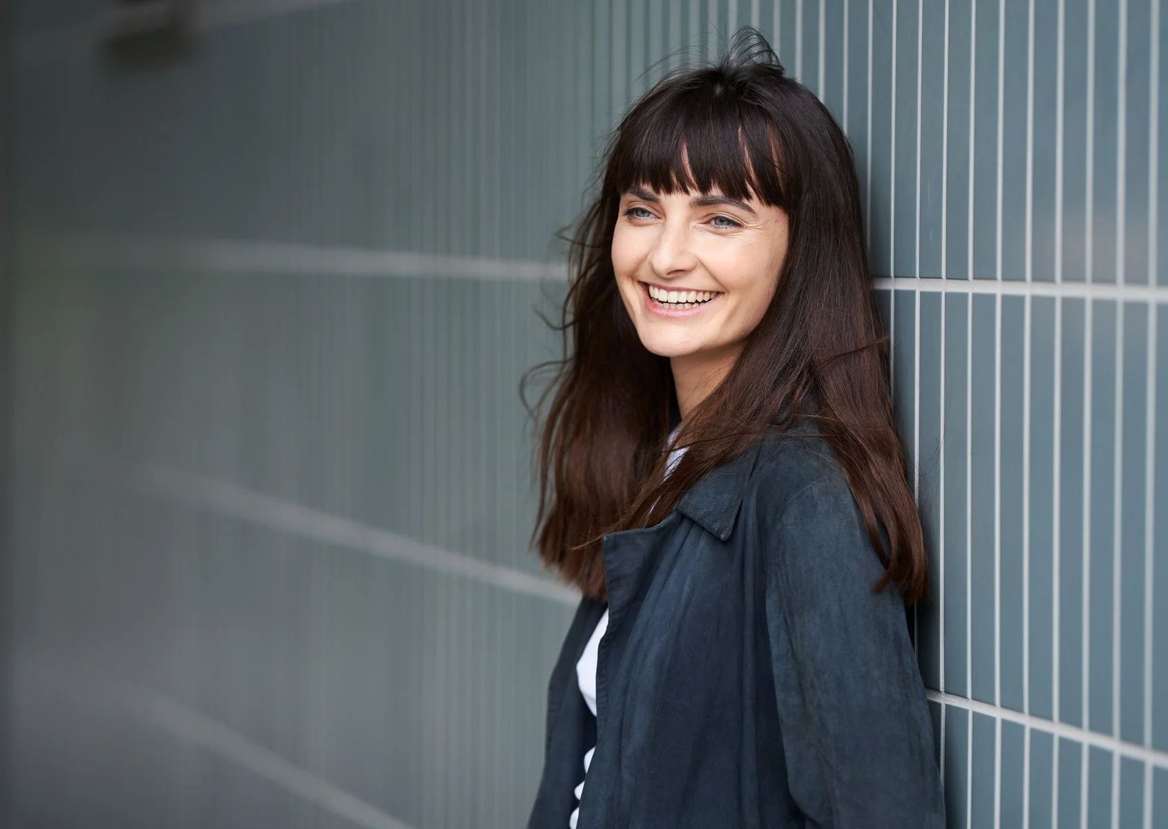 Die deutsche Schauspielerin Paula Schramm in einem stilvollen Porträtfoto mit entspannter Ausstrahlung.