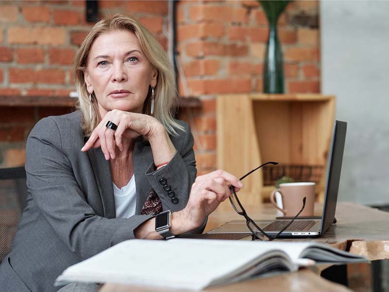 CEO working at a desk with a laptop and notebook in a modern office