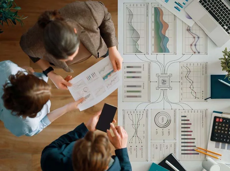Three people analyzing business data, performance charts, and analytics reports.
