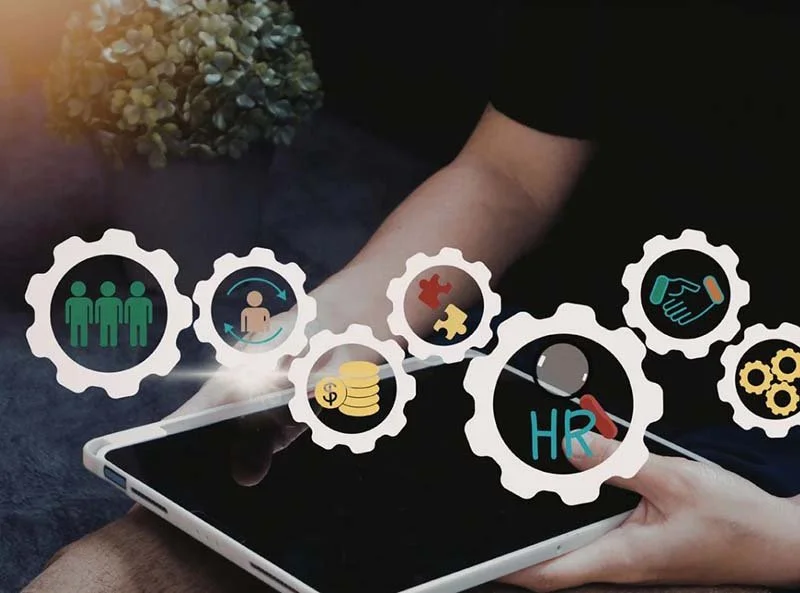 Person using a tablet surrounded by icons representing HR, teamwork, employee management, compensation, collaboration, and business processes.