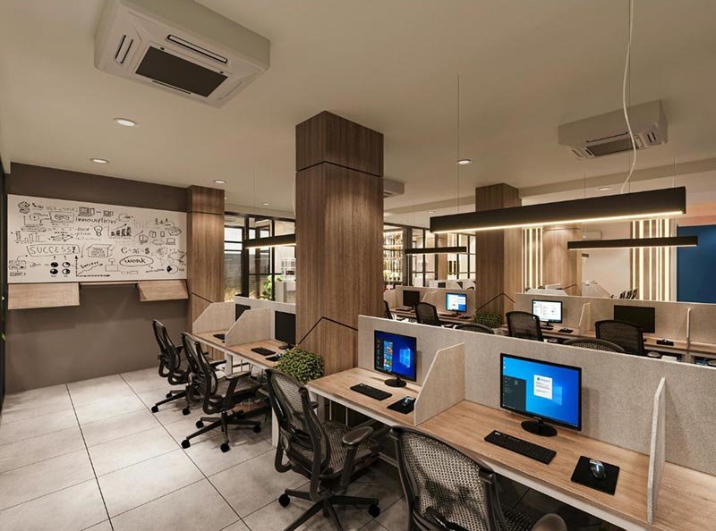 Modern open-plan office with computer workstations, desks, and ergonomic chairs
