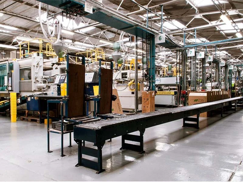 Industrial manufacturing facility with automated conveyor belt system and production machinery on a factory floor