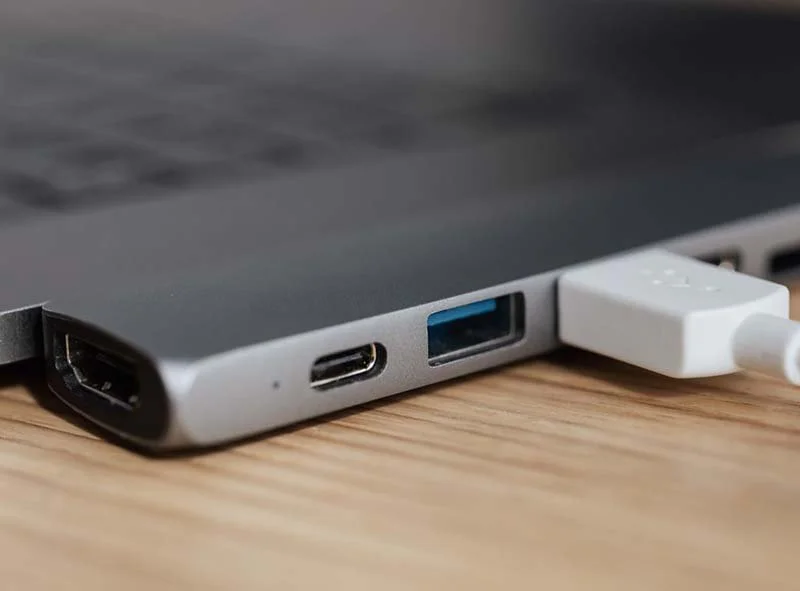 USB-C hub connected to a laptop with HDMI, USB-C, and USB-A ports for device expansion and peripheral connectivity.
