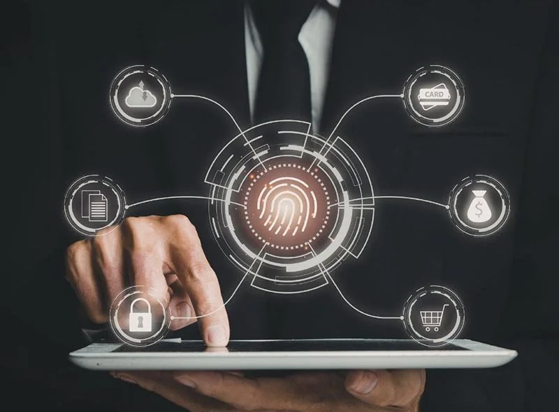 Person using a tablet with a digital fingerprint authentication interface and connected security icons representing cloud storage, payment, shopping, and data protection.