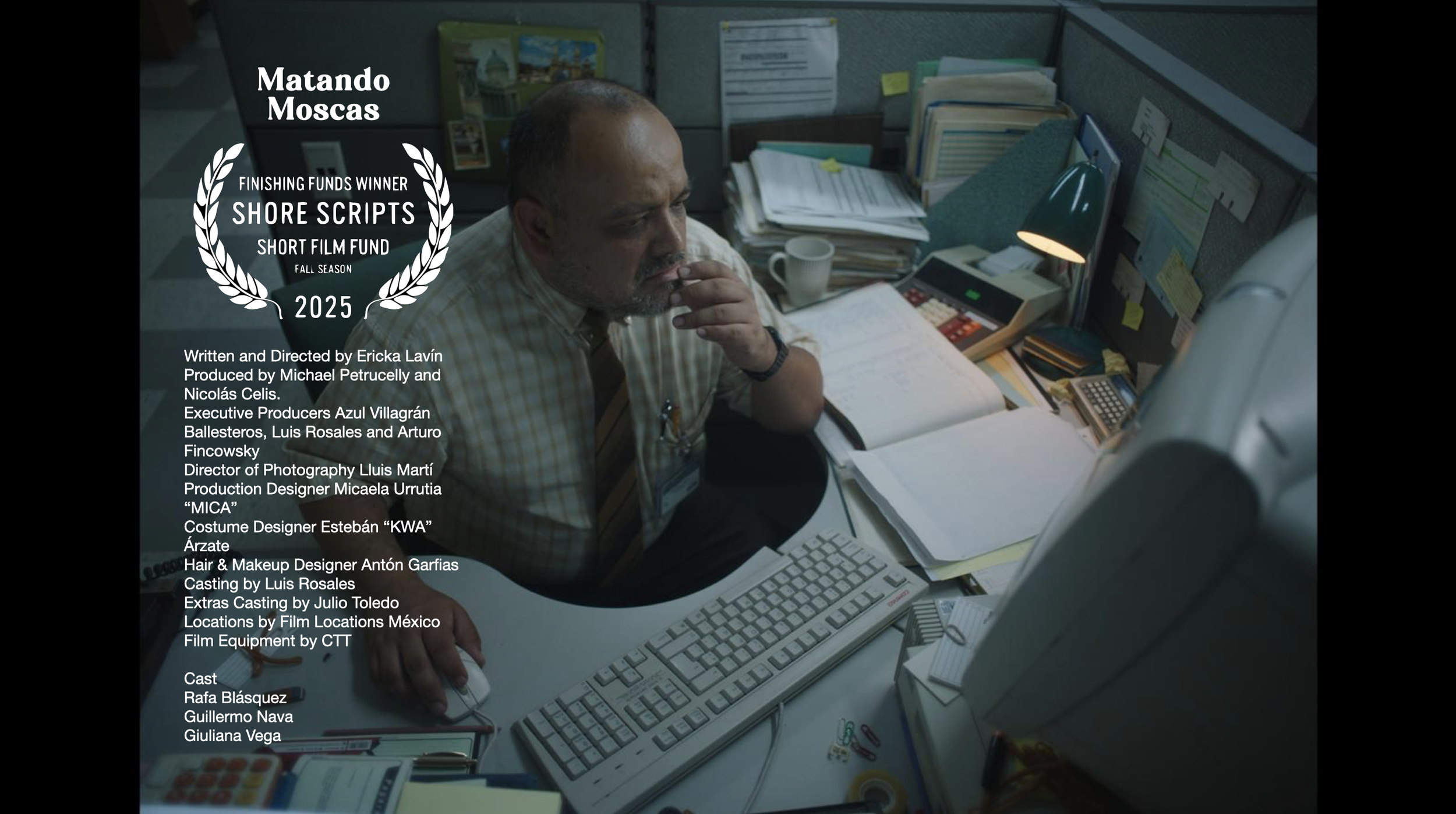 Cluttered office desk with a man in a plaid shirt sitting in front of a computer and papers, with film credits and awards overlayed.