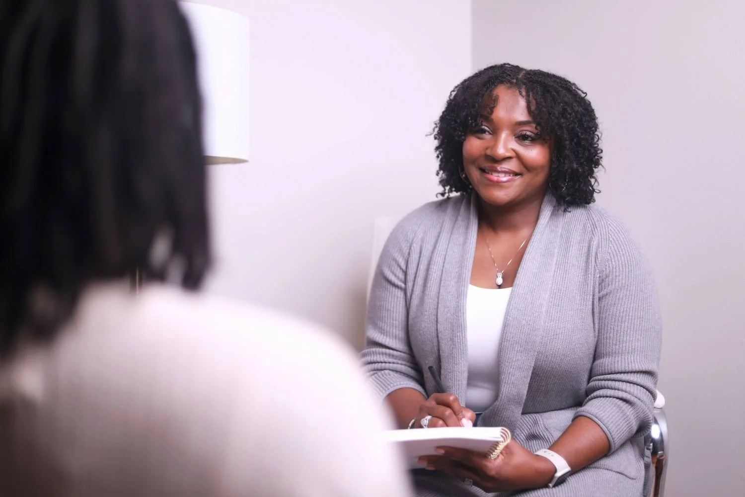 therapist listening to client with notepad