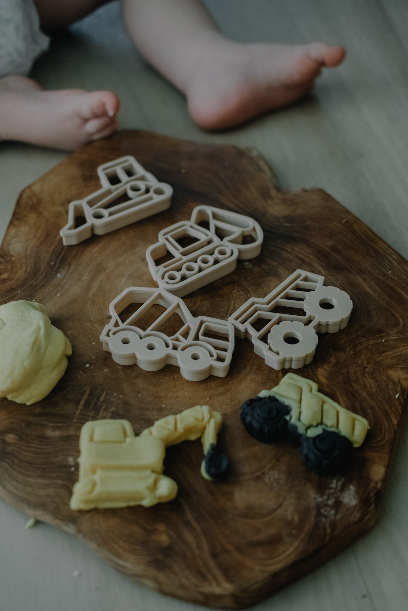 Construction vehicle playdough cutters on timber background — perfect for fine motor skill development.