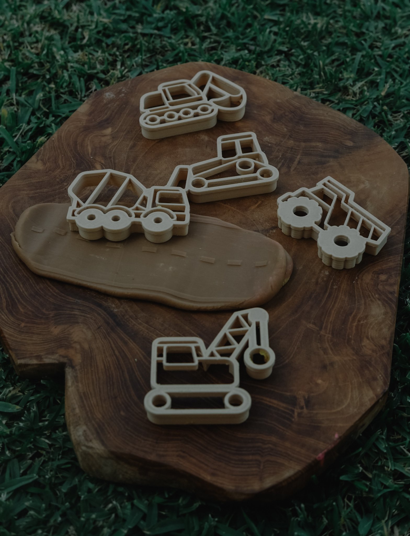 Bulldozer, roller, and excavator playdough imprints on wooden board — part of Kinfolk Pantry’s eco cutter set.