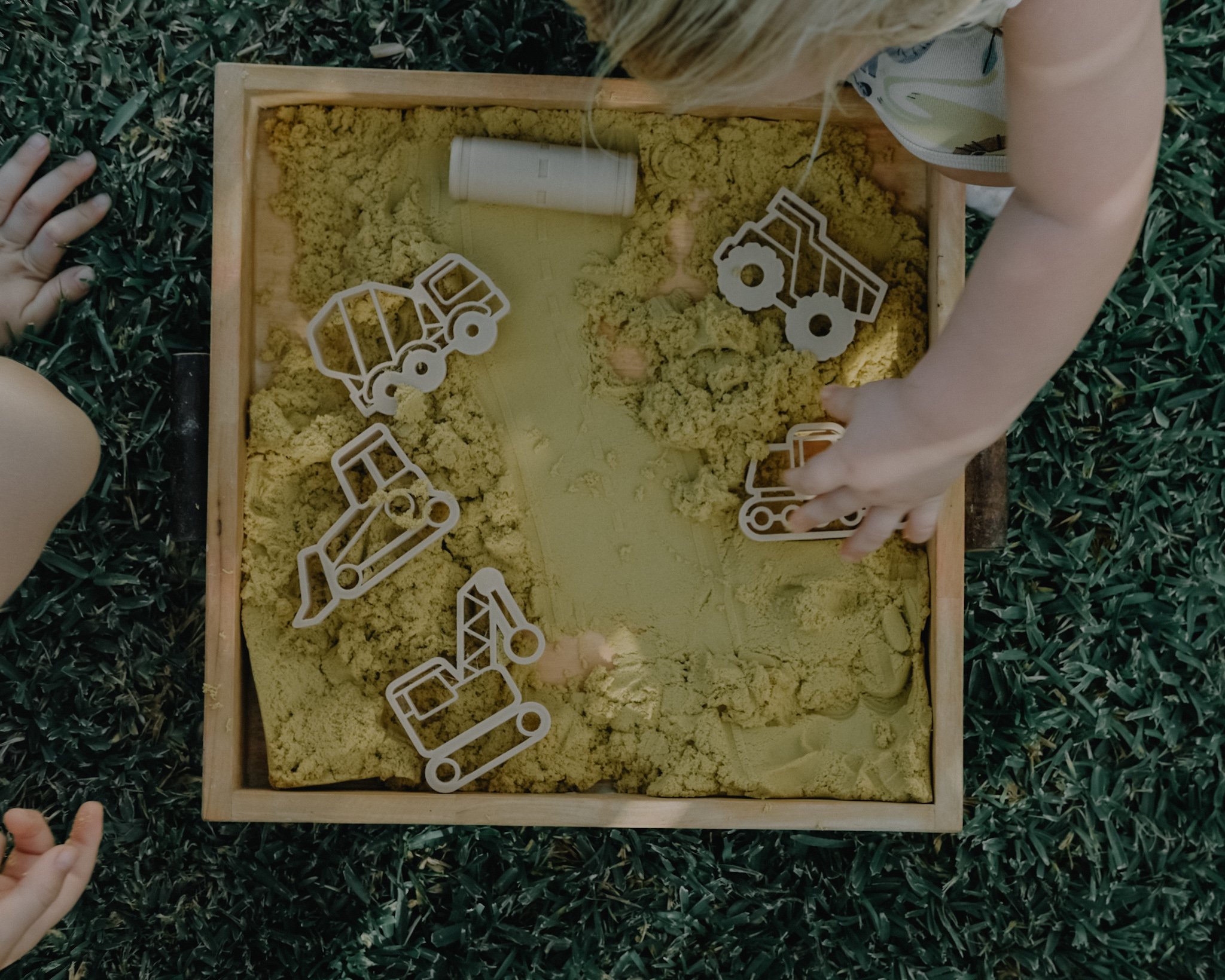 Children using playdough construction tools outdoors — open-ended play inspired by building and creativity.