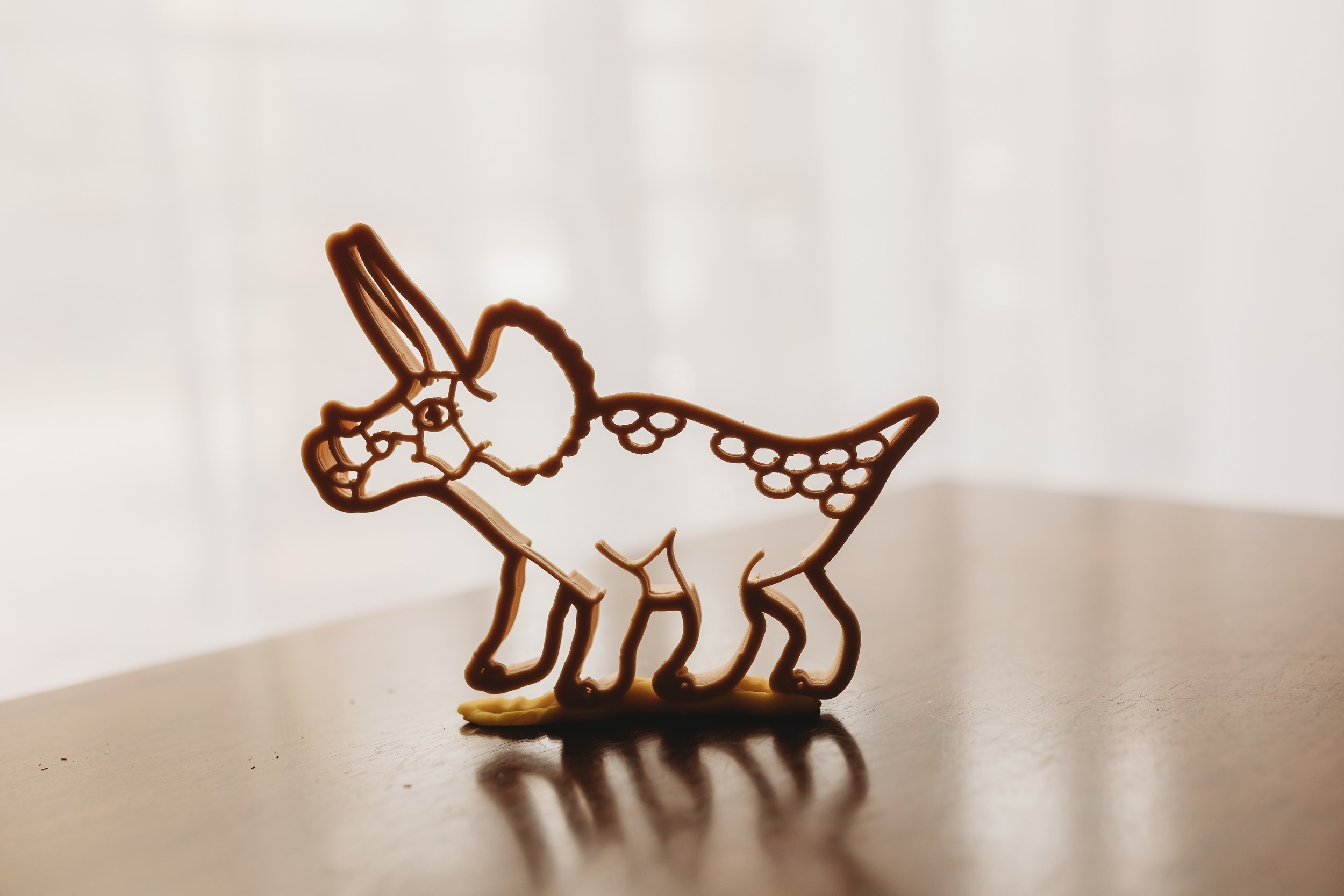 Triceratops eco cutter standing upright on wooden surface with soft lighting