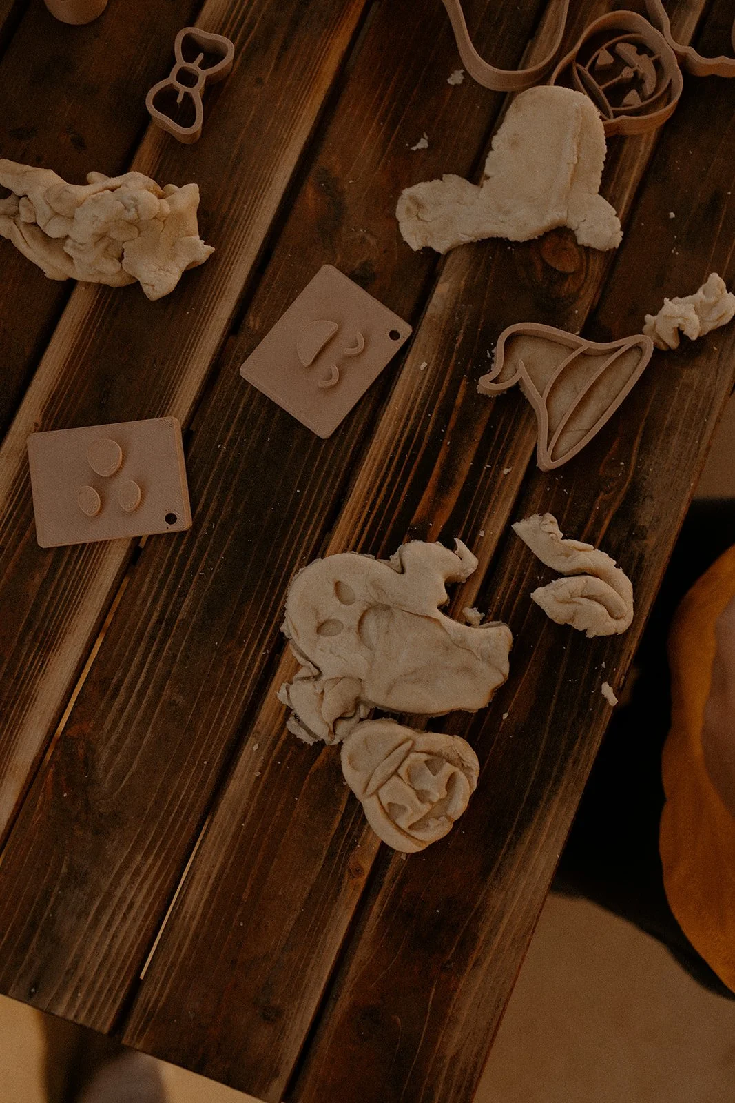 Layered ghost playdough cutter outlines arranged on wooden surface