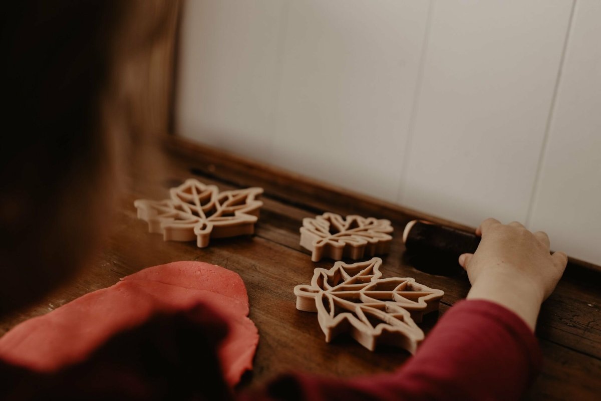 Handcrafted leaf cutters with pressed playdough leaves, surrounded by seasonal nature tools.
