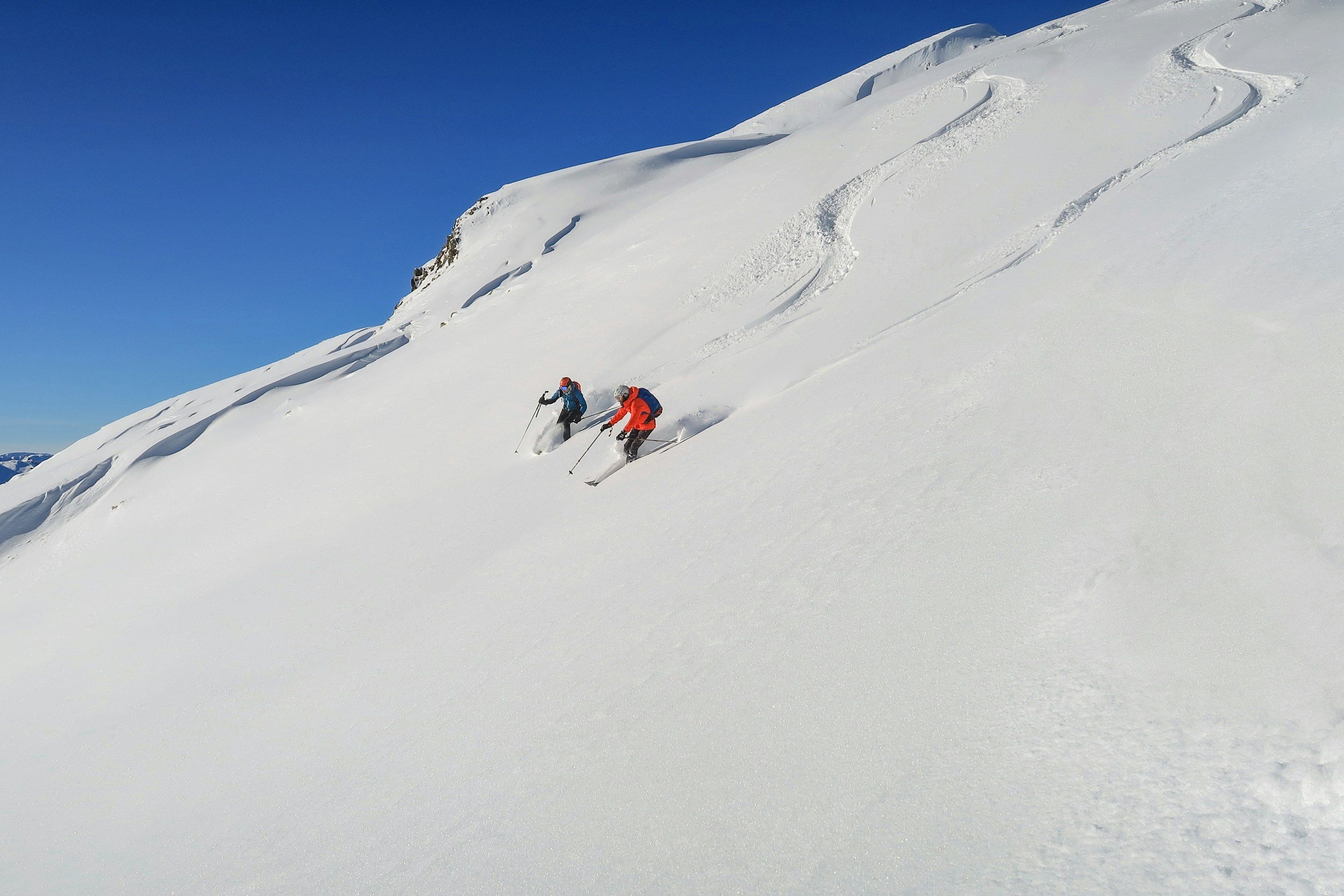two skiiers skiing down mountain performance training