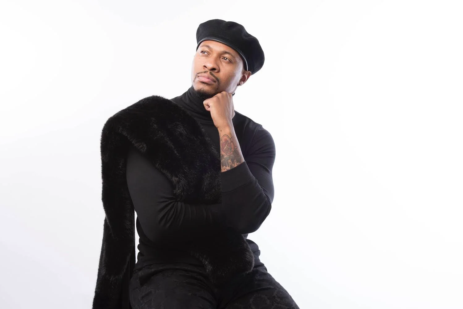 Esaie Touzé dressed in black against a white background