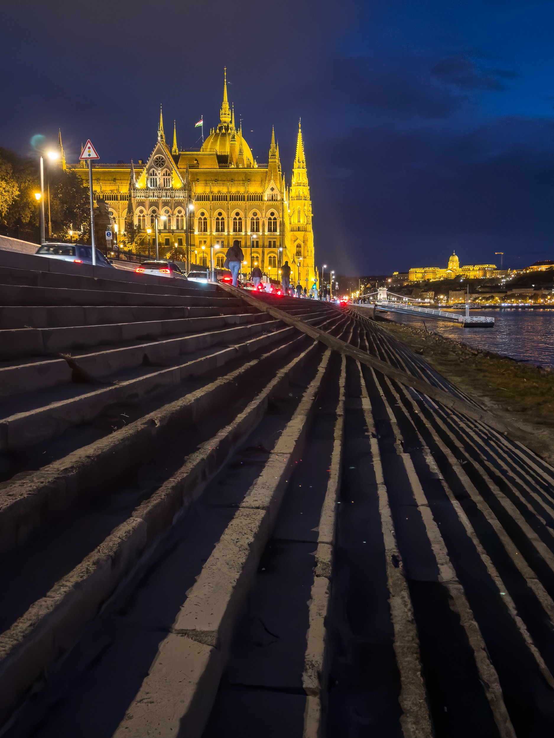 From the shore line of the Danube looking up at the parliament building with the Buda Castle in the background.