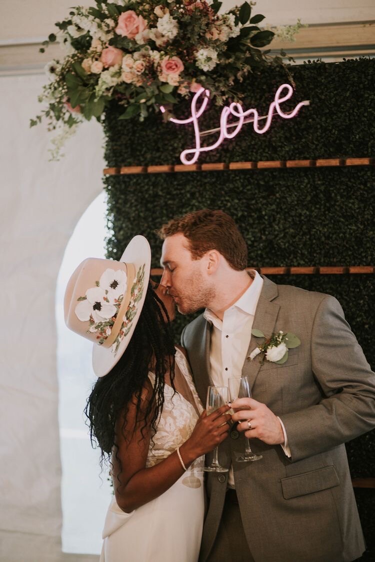 Bride wearing hand painted hat on wedding day.