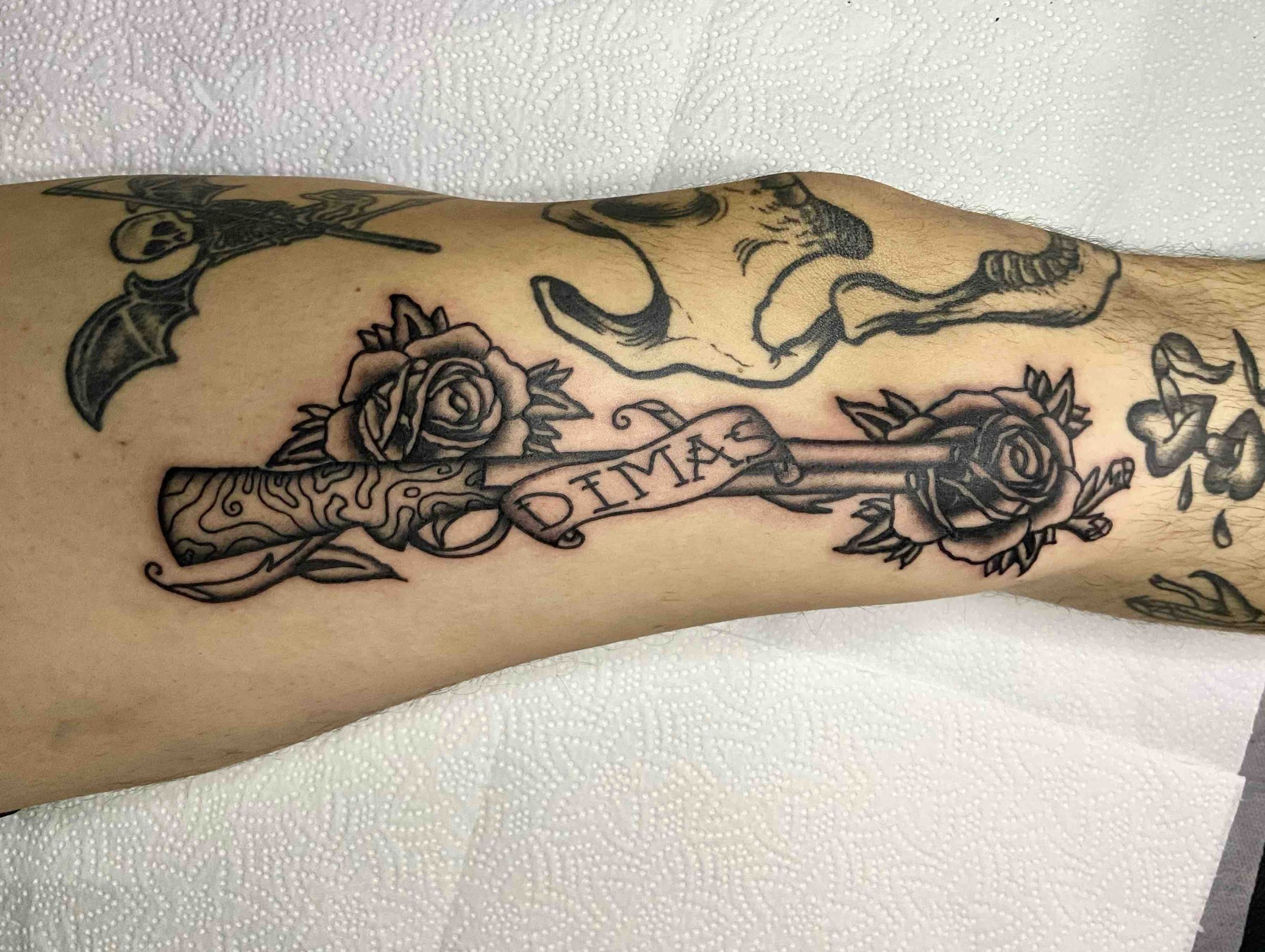 Neo-trad-blackwork-tattoo-shotguns-and-roses.jpeg