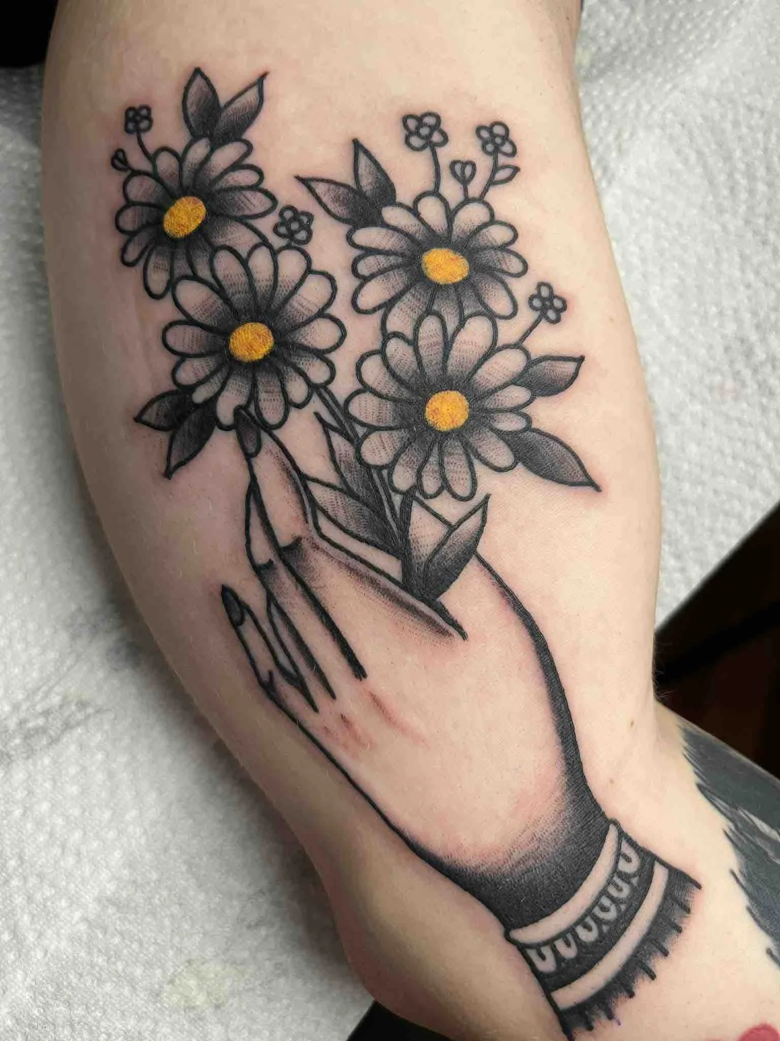 neotrad-daisies-in-hand-leg-tattoo-colourwork.jpeg